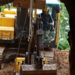 Grosse pelleteuse déposant une petite pelleteuse dans la galerie 