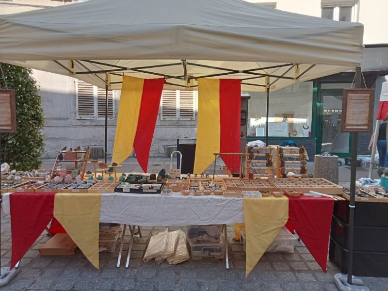 Stand TerraCristaux décoré aux couleurs du duc de Lorraine lors d’une fête médiévale, exposant des minéraux et pierres naturelles.