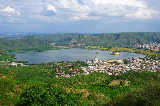 Vue du lac Man Sagar à Jaipur, avec les montagnes Aravalli en arrière-plan sous un ciel clair.