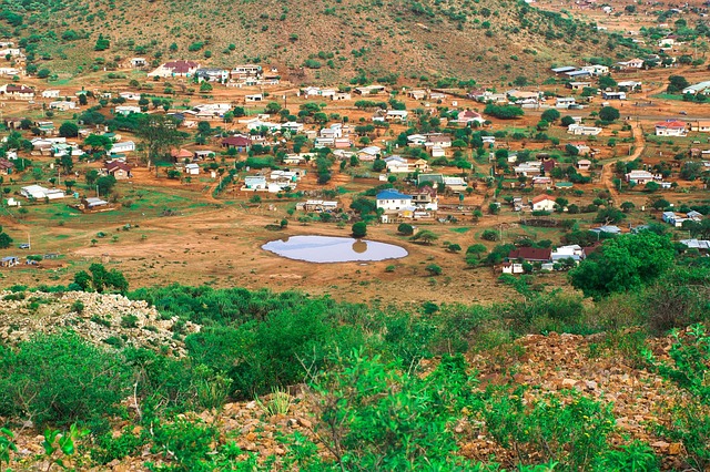 Vue panoramique d’un petit village rural entouré de collines et de montagnes verdoyantes dans la province du Limpopo, Afrique du Sud, avec des habitations.