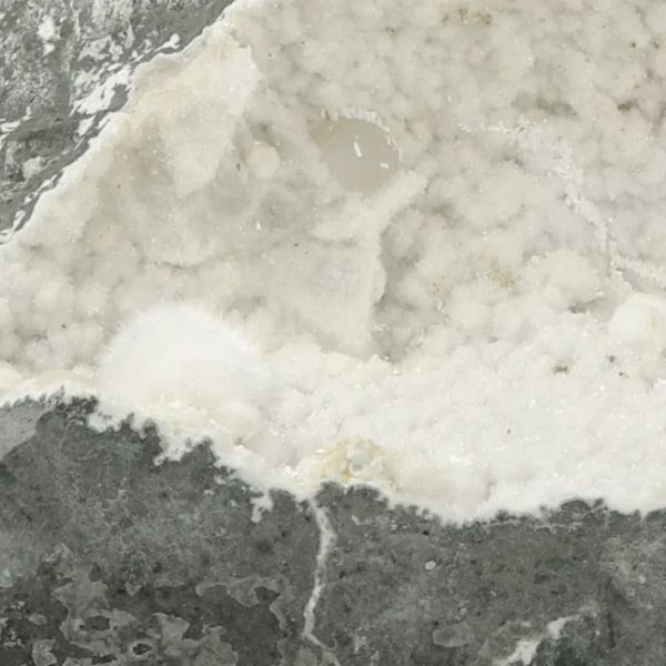 Gros plan sur l’intérieur d’une géode d’Okénite de 3,45 kg provenant de Malad Quarry, Inde, montrant des cristaux blancs translucides sur matrice basaltique, pièce unique pour collection et décoration.